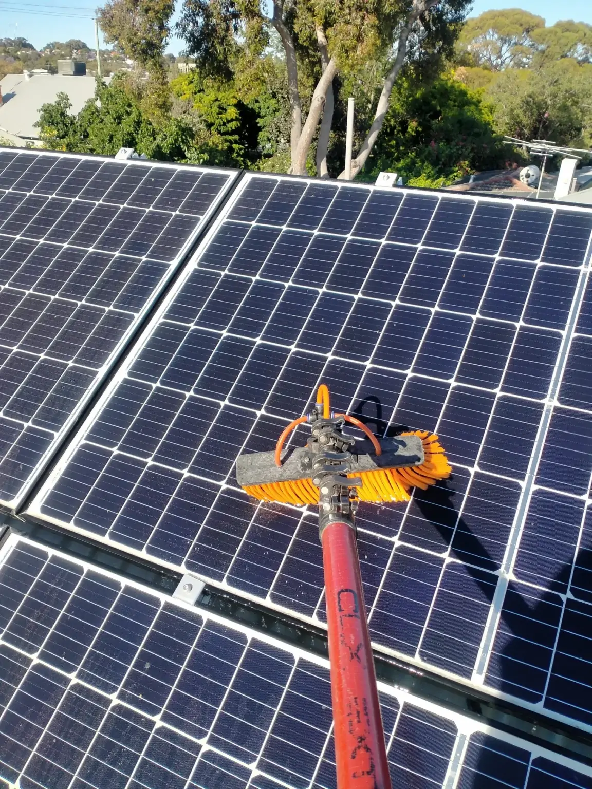 Water-fed brush cleaning the surface of commercial solar panels in Perth