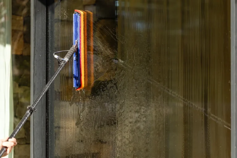 Squeegee mid-stroke on wet glass during a window clean