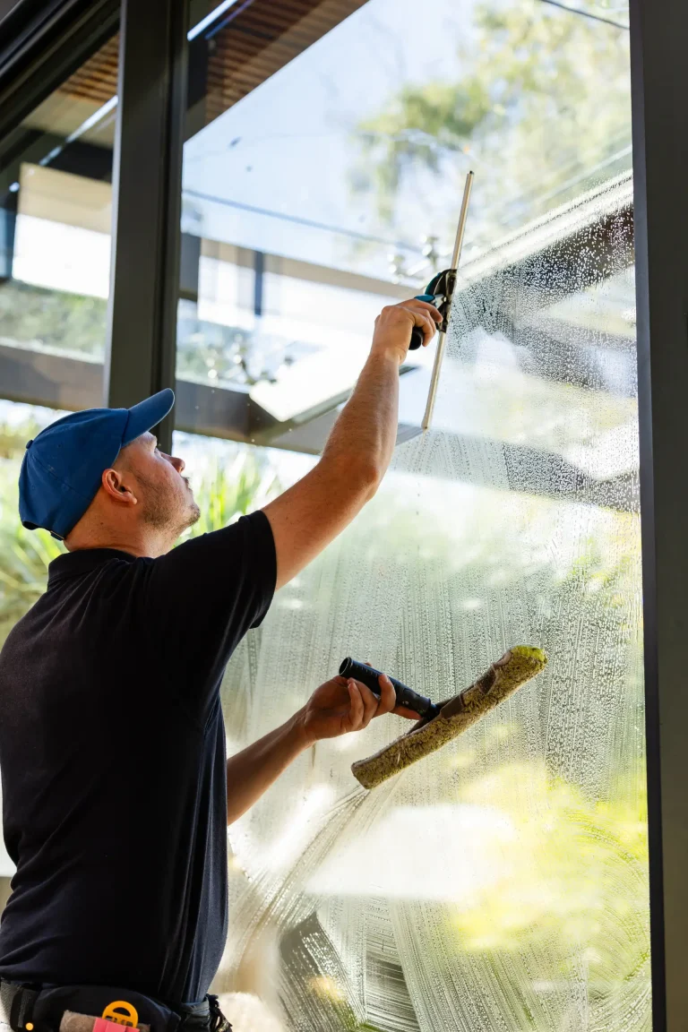 Window cleaning with squeegee and scrubber in daylight at a Perth property