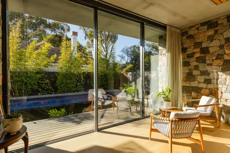 Sliding glass doors polished to a clear finish, deck and pool beyond