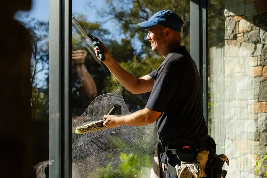 Coates Window Cleaning technician squeegeeing a large window at a Perth home