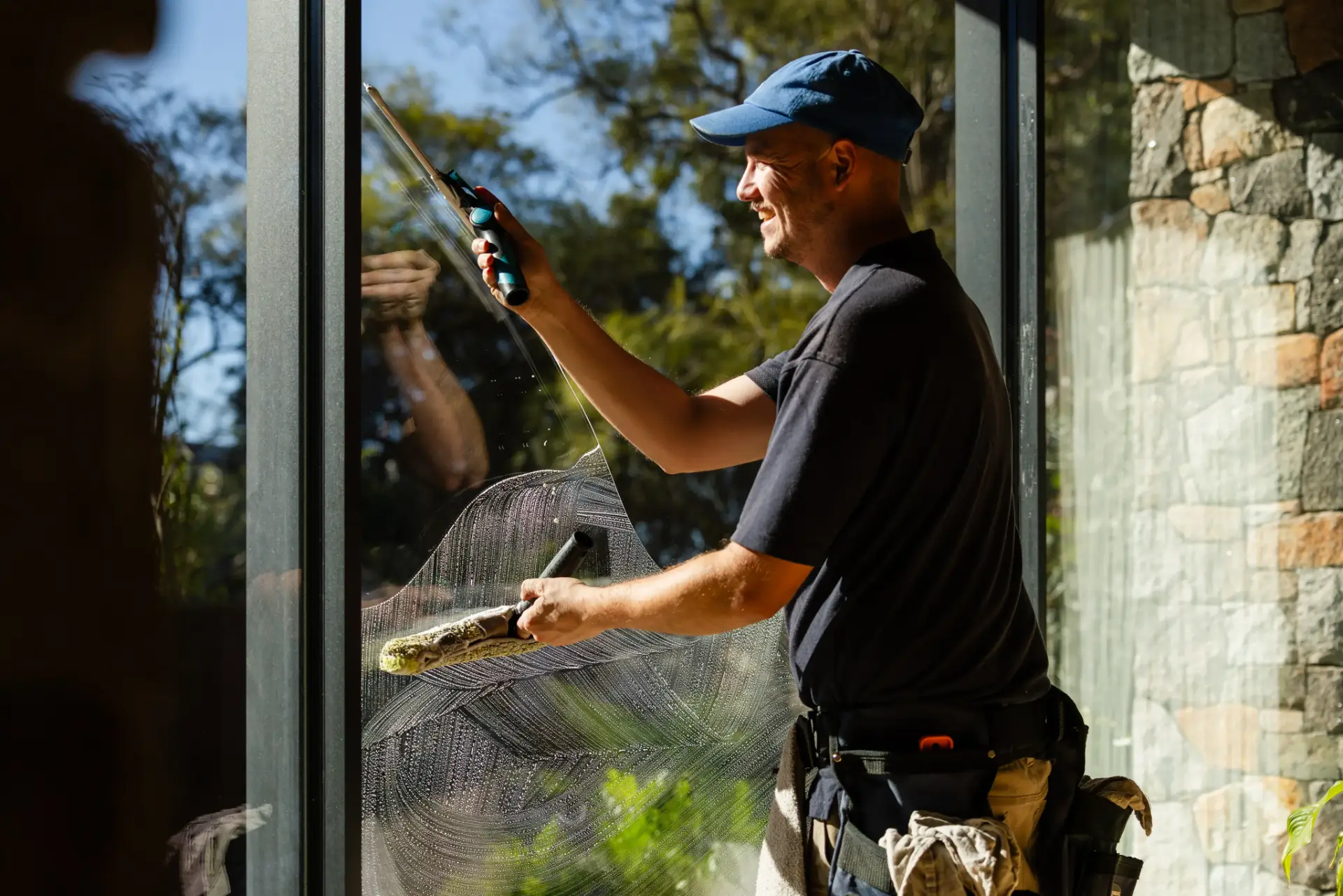 Coates Window Cleaning technician squeegeeing a large window at a Perth home