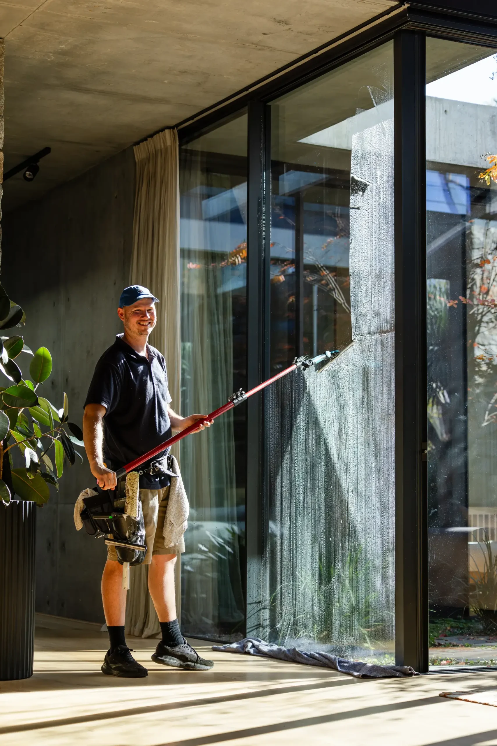 Indoor window cleaning with a long-handled tool at a Perth residence