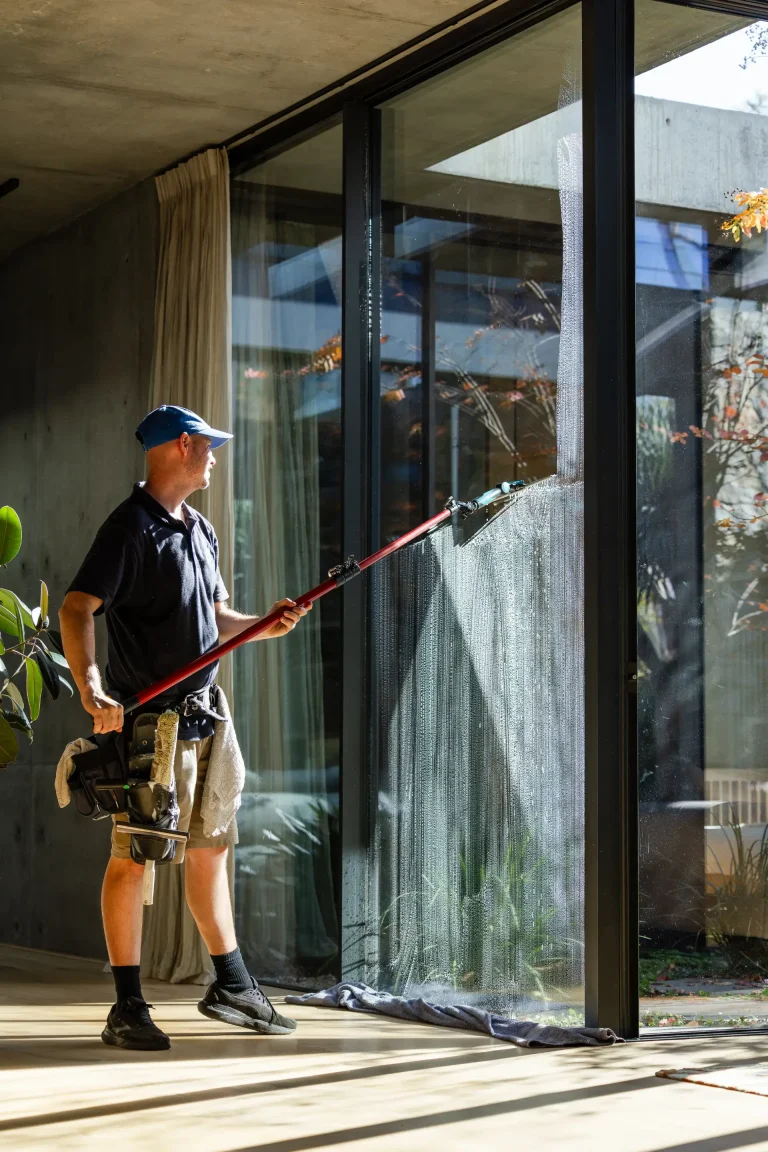 Cleaning full-height glass walls inside a modern building in Nedlands, Perth