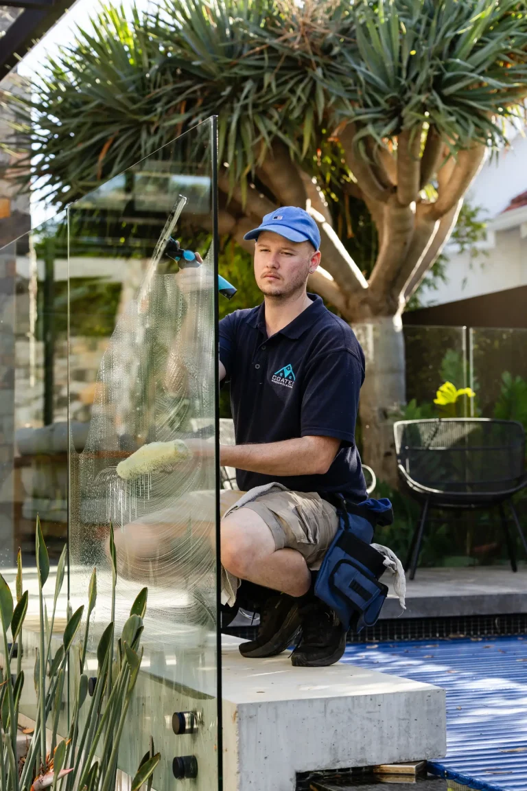 Scrubbing a glass pool fence panel at a Nedlands home in Perth