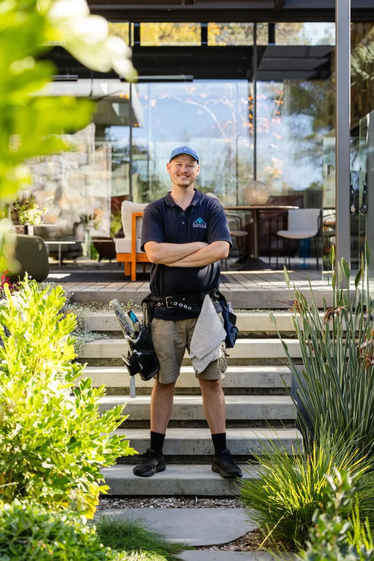 Coates Window Cleaning technician smiling outside a modern Perth home