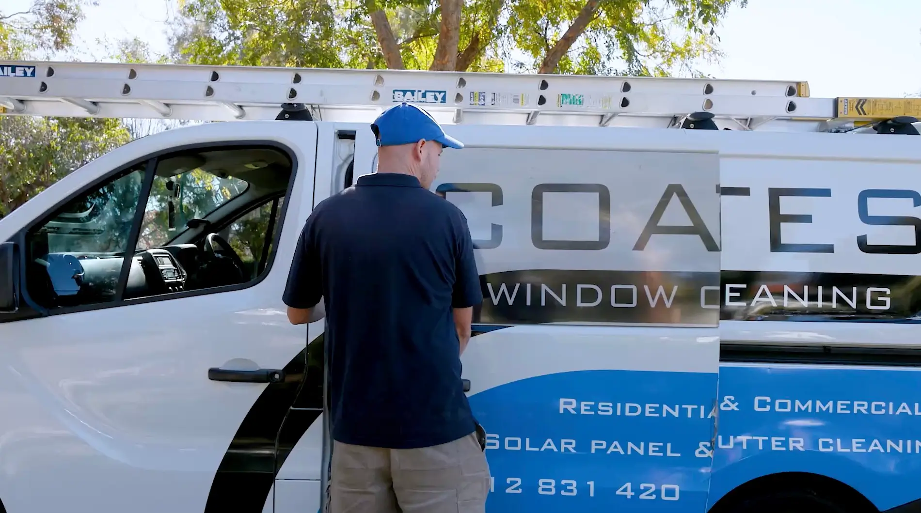 Coates Window Cleaning technician beside the sign-written company van in Perth