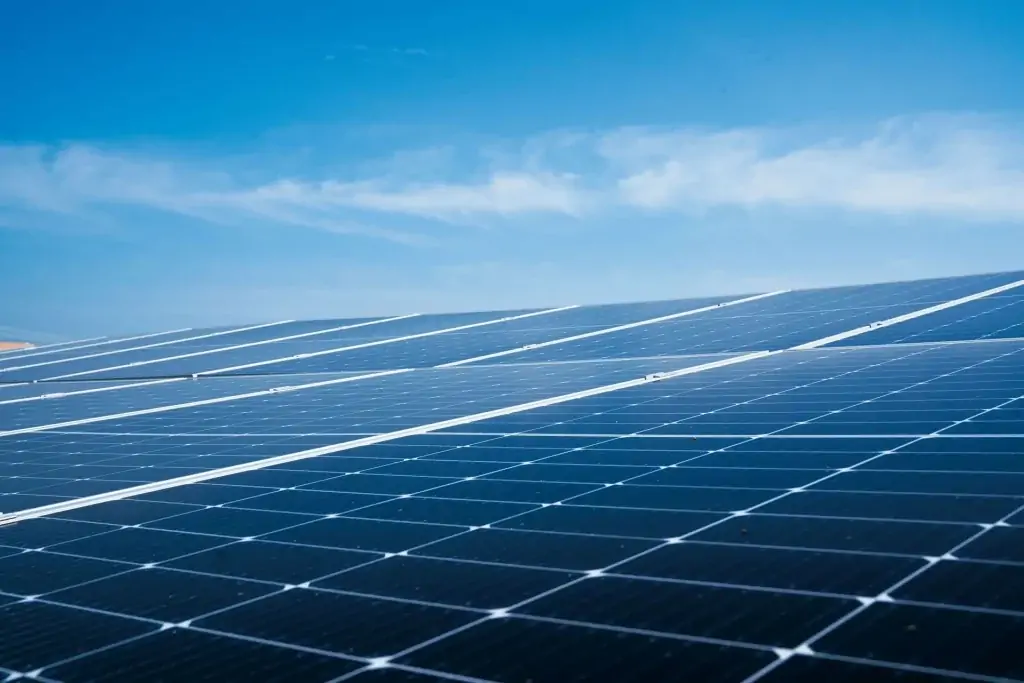 Rows of solar panels under a clear blue sky, generating renewable energy with the help of professional Commercial Solar Panel Cleaning to maximize efficiency and performance.